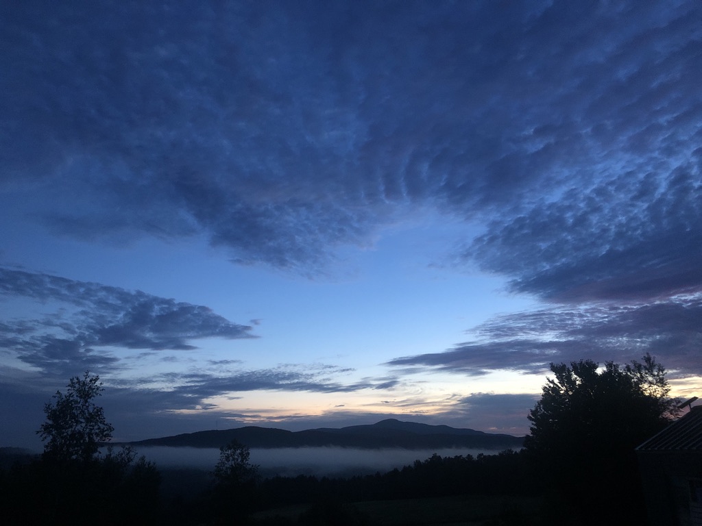 Dramatic blue sunrise clouds above Cloud River and Mt. Sutton from Roméo