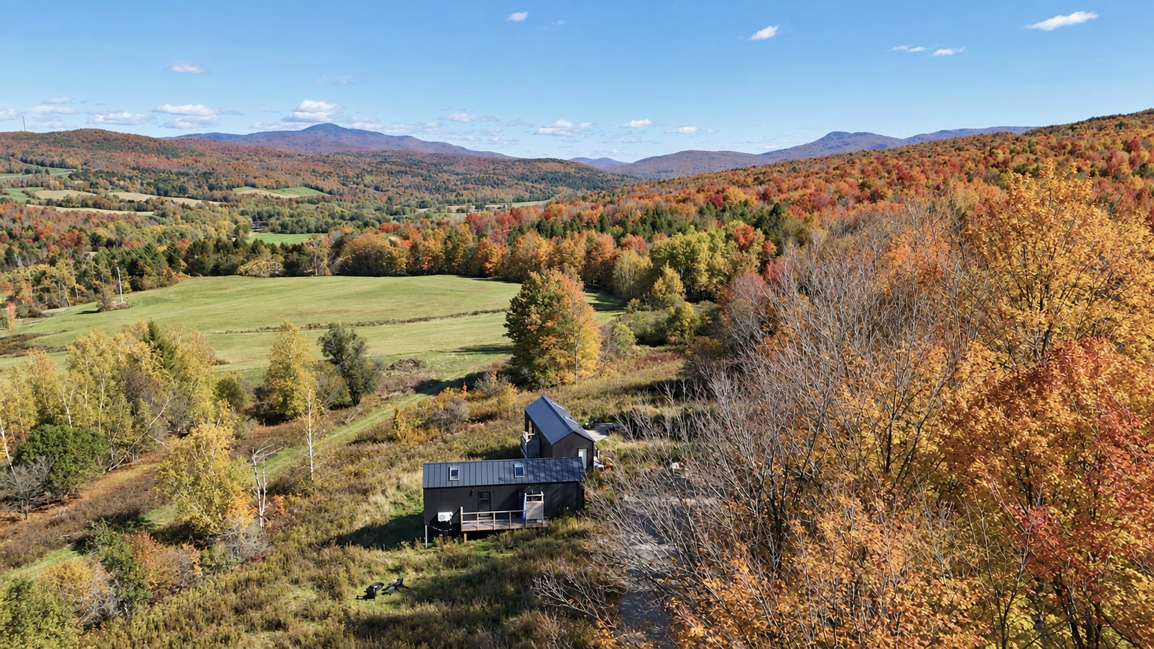 Maisons Alice and Roméo set apart on a hillside overlooking the autumn Missisquoi River Valley and Green Mountains